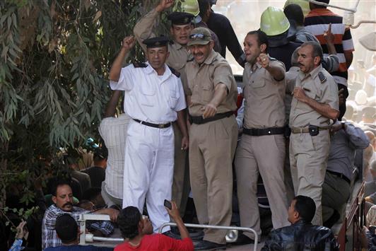 رجال شرطة مصريون يبكون زميلاً لهم قتل في تفجير المنوفية، خلال تشييعه في القاهرة امس (ا ف ب)