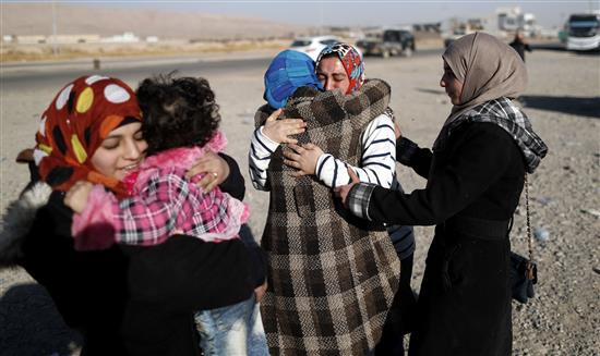 عراقيات من عائلة واحدة يلتقين مجدداً بعد فراق دام عامين في برطلة شرق الموصل أمس (أ ف ب)