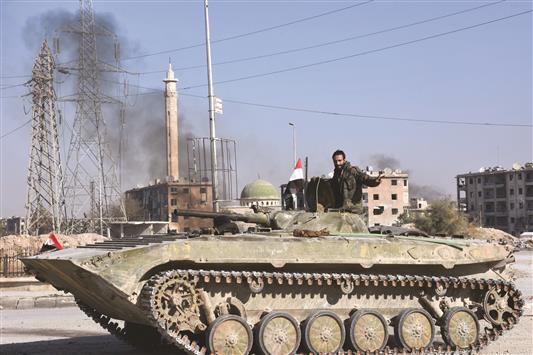 جندي سوري يقود دبابة في حي الحيدرية شرق مدينة حلب أمس (أ ف ب)