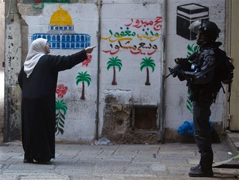 فلسطينية تصرخ في وجه جندي احتلال اسرائيلي في القدس المحتلة أمس (أ ف ب)