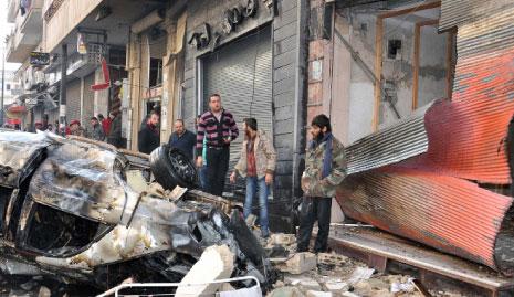 سوريون يعاينون مكان التفجير في حي عكرمة أمس (أ ف ب) 