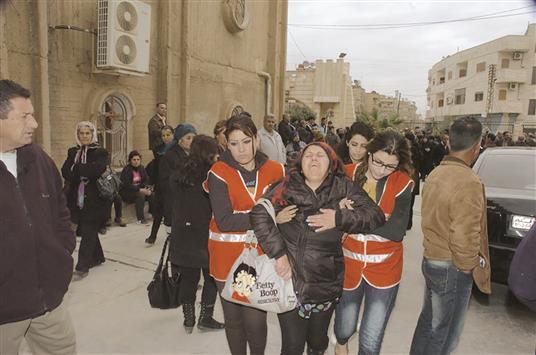 سورية اشورية تنتحب من جرائم «داعش» بعد فرارها مع عائلات اخرى الى الحسكة امس («سانا»)