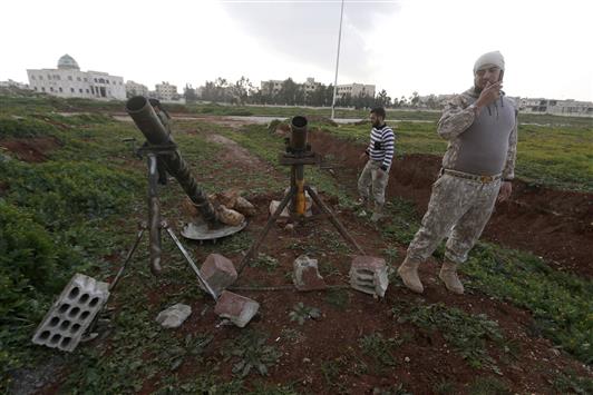 مسلحان من "فرقة احفاد حمزة" قرب مدفعي هاون في ريف حلب امس الاول (رويترز)