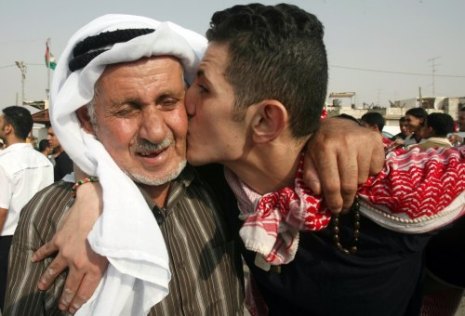 أسير فلسطيني محرّر يقبّل والده في مركز السلطة الفلسطينيّة في رام الله أمس
