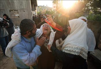 أقرباء الشهيد محمد غبن ينتحبون خلال تشييعه في غزة أمس.