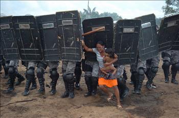 الصورة التي حازت على المرتبة الاولى في الفئة العامة الجديدة للمصور البرازيلي لويس فاسكونسيلوس: امرأة تحاول منع عناصر من الشرطة من التقدم لمطاردة ابناء قبيلتها في البرازيل