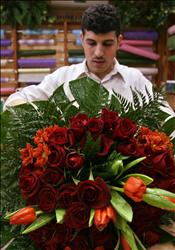 بائع زهور في الرياض يعد باقة من الورد الأحمر لمناسبة عيد العشاق