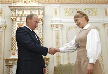 بوتين وتيموشينكو يتصافحان خلال لقائهما في ضواحي موسكو أمس