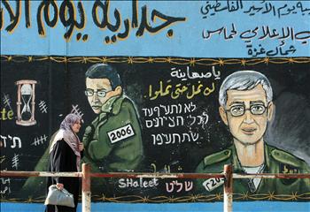 جدارية تحمل صورة شاليت، تحذر الاحتلال في جباليا بغزة أمس