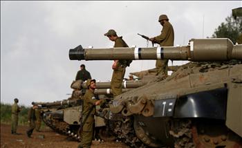 جنود إسرائيليون قرب دباباتهم خلال تدريب في الجولان المحتل أمس