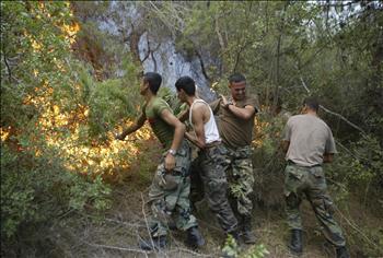 جنود يخمدون الحرائق بأيديهم في عكار امس