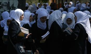 طالبات فلسطينيات يغادرن مدرستهن بعد أول يوم دراسي في غزة أمس.
