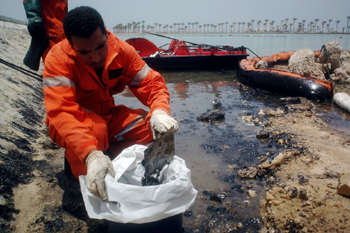 عامل مصري يجمع النفط المسكوب في بقعة التسرب