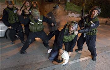 عناصر من شرطة الاحتلال الإسرائيلي ينهالون بالضرب على شاب فلسطيني خلال تظاهرة احتجاج على هدم مبنى في الطيبة أمس