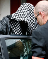 عنصر أمن يرافق الياس حباج إلى مقر الشرطة لاستجوابه