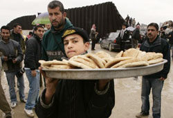 فلسطيني يبيع الخبز على المعبر بين غزّة والأراضي المصريّة أمس