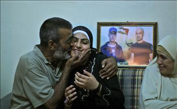 فلسطينيات أقارب الأسيرة فاطمة الزق يحتفلون بقرب الإفراج عنها وطفلها المولود في الأسر، أمام منزلها في غزة أمس.