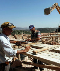 فلسطينيان يعملان في مستوطنة «ياكير» في نابلس أمس.