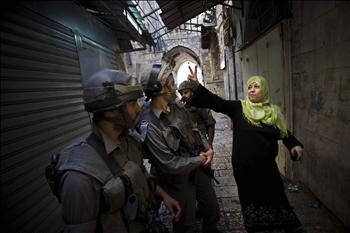 فلسطينية ترفع شارة النصر في وجه عناصر للاحتلال عقب المواجهات في القدس المحتلة أمس
