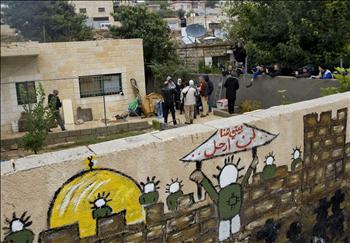 فلسطينيون يتحدثون إلى صحافيين أمام المنزل في القدس المحتلة أمس