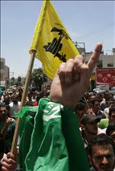 فلسطينيون يرفعون أعلاماً لحركة حماس و»حزب الله« خلال تشييع المقاوم في حماس شهاب النتشة في الخليل أمس.
