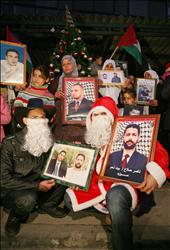 فلسطينيون يرفعون صوراً للأسرى خلال اعتصام أمام مقر الصليب الأحمر في بيت لحم أمس