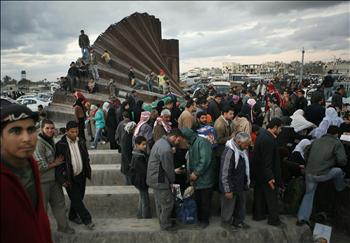 فلسطينيون يعبرون فوق السور الحدودي المهدّم على معبر رفح باتجاه مصر أمس