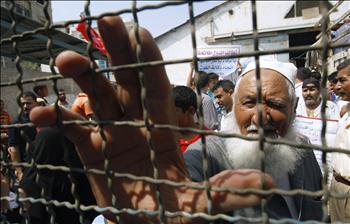 فلسطينيون ينتظرون الحصول على مساعدات من الأمم المتحدة في مخيم رفح جنوبي قطاع غزة أمس.
