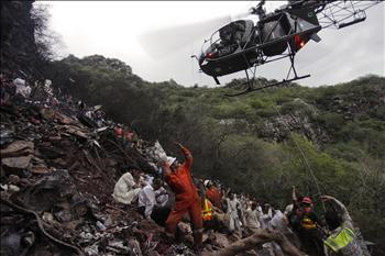 مروحية باكستانية تنتشل جثث ضحايا الطائرة التي تحطمت قرب إسلام أباد أمس
