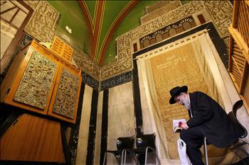 مستوطن يهودي يؤدي الصلاة داخل الحرم الإبراهيمي أمس.